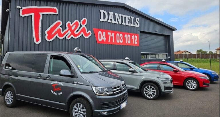Flotte de véhicules Taxi Daniels devant le siège à Solignac-sur-Loire, incluant un van 8 places et des voitures récentes.